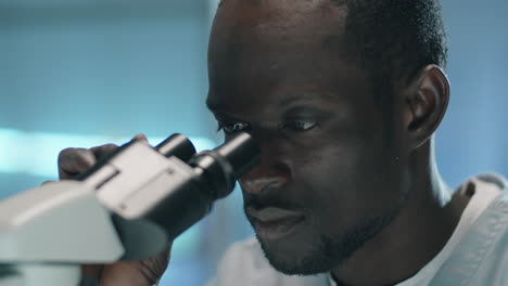 Schwarzer-Wissenschaftler-Benutzt-Mikroskop-Im-Labor